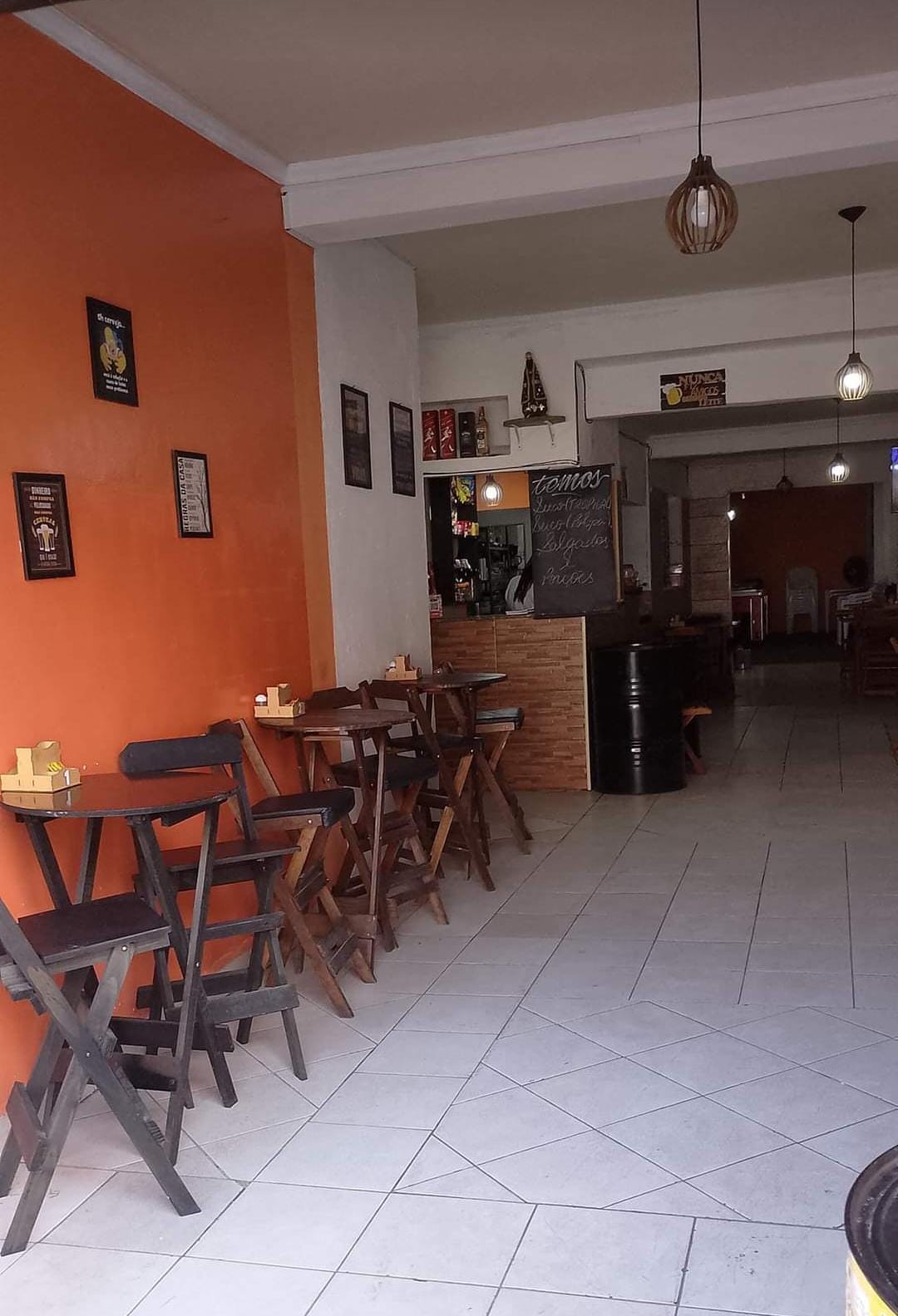 Salão interno da marmitaria com mesas e balcão